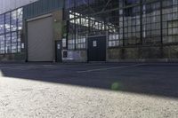 a lone white motorcyclist parked near the side of the street in an industrial area