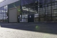 a lone white motorcyclist parked near the side of the street in an industrial area