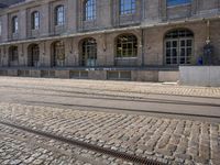 there are tracks that look like tracks on the street in front of a big building