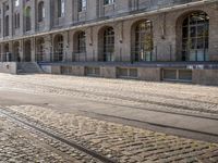 there are tracks that look like tracks on the street in front of a big building