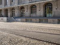 there are tracks that look like tracks on the street in front of a big building