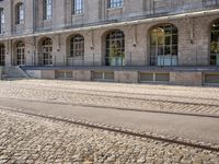 there are tracks that look like tracks on the street in front of a big building