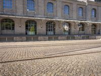 there are tracks that look like tracks on the street in front of a big building