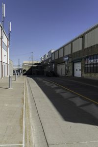 this is a very empty street at the curbside of a factory building with one side in motion