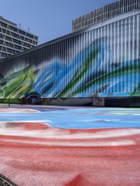 an image of painted mural with cars in the background outside the building on the right side