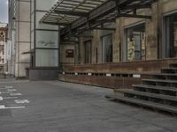 an empty building with signs on the street and people on bikes in traffic passing by