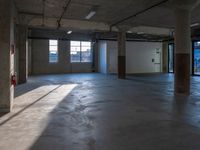 a empty warehouse room with windows and concrete walls, in the afternoon sun light coming through