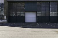 a fire hydrant in front of a warehouse building with a white door and a sign