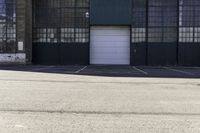 a fire hydrant in front of a warehouse building with a white door and a sign