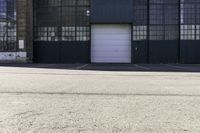 a fire hydrant in front of a warehouse building with a white door and a sign