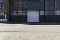 a fire hydrant in front of a warehouse building with a white door and a sign