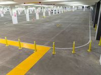 an empty parking garage with white and yellow safety barriers around it in a shopping mall