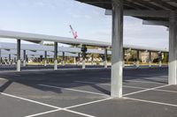 a parking lot in an airport with overhead shade area and several other parking bays in the background