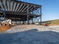 a picture of a building being built on a field near a forest in the background