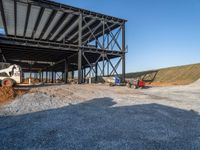 a picture of a building being built on a field near a forest in the background