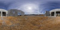 a circular panorama shows two concrete buildings under construction and a full moon in the sky