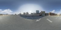 a reflection of an empty parking lot with the sun beaming through a big window, and several buildings