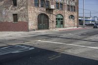 a stop sign sitting in the middle of an empty road near a building with a number four on it