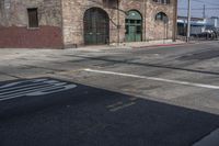 a stop sign sitting in the middle of an empty road near a building with a number four on it