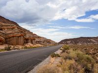 the road in the middle of a desert area that is winding through the mountain landscape