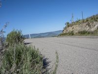 the street is paved and empty of people and motorcycles parked near a mountain area and trees