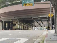 a yellow bicycle sits parked under a bridge in an empty city space for pedestrians and pedestrians