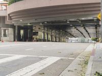 a yellow bicycle sits parked under a bridge in an empty city space for pedestrians and pedestrians