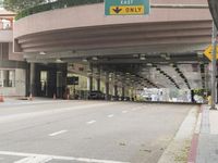 a yellow bicycle sits parked under a bridge in an empty city space for pedestrians and pedestrians