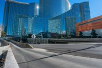 tall glass towers are rising into the sky near a freeway and sidewalk with a bicycle