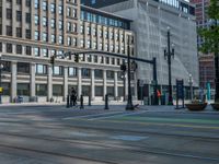 the green paint is painted on a bike path in front of an office building and large, trees