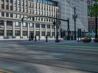 the green paint is painted on a bike path in front of an office building and large, trees