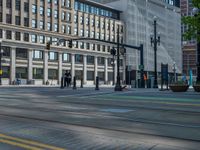 the green paint is painted on a bike path in front of an office building and large, trees