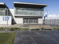 an empty building with many glass doors and large windows on it, sitting on cement