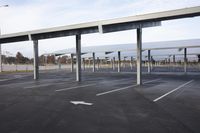 an empty car park with parked cars on either side and empty space for vehicles to use