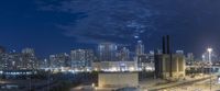 view of city skyline at night from highway elevated viewpoint overlooking skyline with traffic and buildings