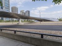 an overpass above the street with lots of people riding bicycles on it, some with buildings in the background