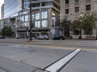 a view of a city street through some buildings while cars are stopped on the road