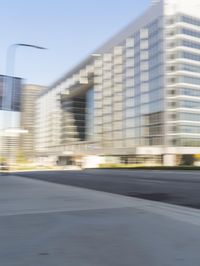 a street scene with blurry cars on the street and a building in the background