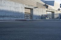 a building with a ramp over it in front of a road with yellow stripes on the street