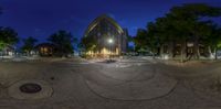 a view through a fish eye lens at night time with buildings and trees in the background