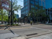 the green paint is painted on a bike path in front of an office building and large, trees