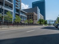 an empty street with buildings and parked cars on the sidewalks and green lanes on the sidewalk