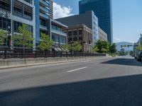 an empty street with buildings and parked cars on the sidewalks and green lanes on the sidewalk