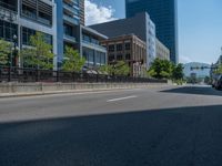 an empty street with buildings and parked cars on the sidewalks and green lanes on the sidewalk