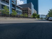 an empty street with buildings and parked cars on the sidewalks and green lanes on the sidewalk