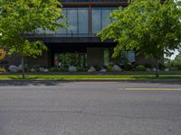 a building with a logo painted on the side near a street that has a sidewalk next to it