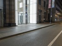 a city street is empty and deserted at night, with no traffic on it's sidewalks