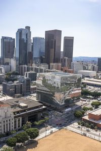 the city is full of tall buildings and green trees that line the edge of this park