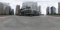 the street is empty in this wide angle view of this cityscape seen from a fish eye lens