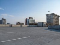 several large empty parking spaces in the city with buildings nearby in front of them -